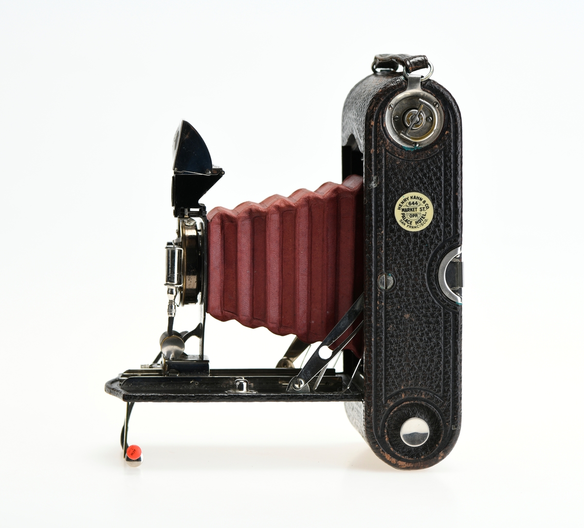Et belgkamera for 116-film fra Kodak. No. 1A Folding pocket ble laget i flere versjoner mellom 1899 og 1915 og var det første kameraet fra Kodak til å bruke 116-film. Av de fire versjonene (Model A, B, C, D) var denne Model D den første til å ha en objektivplate i metall, mens de tidligere versjonene hadde en objektivplate i tre. 

Kameraet tar bilder på 6,5x11 cm. Det har 3 lukkertider i tillegg til åpen lukker (B). I tillegg til lukkeren på objektivet har kameraet også en snorutløser. På skinnen som belgen er festet i er det et lite hjul for å stoppe belgen i ulike posisjoner merket med fokusavstand. Det er en søker foran på objektivplaten som kan roteres for å ta landskapsbilder, og søkeren har et deksel som kan vippes opp. Baksiden kan åpnes for å sette inn film, og det har et rødt vindu for å se om det er film i. Luken til belgen åpnes med en knapp på siden av kameraet, på luken er det en fot som kan brettes ut. Håndtak i skinn på toppen. Kameraet kommer i en veske av skinn. Med kameraet følger også en mekanisk opptrekkbar selvutløser som kan festes på enden av snorutløseren.