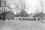 Reprofotografi med bristfällig kvalitet som oavsett ger oss en sällan dokumenterad vy från Linköping. Utblick från Sankt Larskyrkan mot del av bebyggelsen inom nuvarande kvarteret Borgmästaren, närmare bestämt Ågatan 21 och 23. Året är 1903.