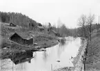 Motiv från Nykvarn beläget någon kilometer uppströms Storån norr om Kisa. Fotoåret 1902 var kvarnen som legat under Torps Frälsegård nedlagd sedan en tid. Den sista noterade mjölnaren Carl Johan Carlsson hade avflyttade 1875. Till höger skymtar banvallen till Östra centralbanan mellan Linköping och Vimmerby.