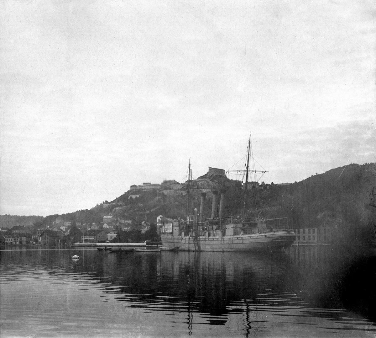 Skuteportrett fra havnen i Halden, fotografert i forbindelse med Telemarkens Linjebataljon Fredriksten festning, 1905. Fredriksten festning sees i bakgrunnen.

Fartøyet på bildet er Kanonbåt av 1. klasse "Sleipner", sjøsatt i 1878.