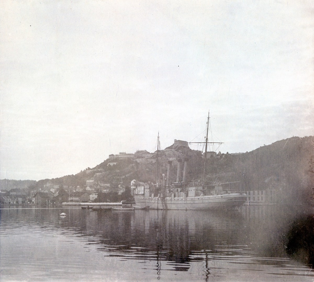 Skuteportrett fra havnen i Halden, fotografert i forbindelse med Telemarkens Linjebataljon Fredriksten festning, 1905. Fredriksten festning sees i bakgrunnen.

Fartøyet på bildet er Kanonbåt av 1. klasse "Sleipner", sjøsatt i 1878.