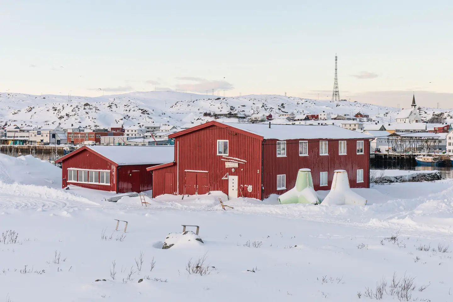 Berlevåg Havnemuseum og en tetrapod i snø om vinteren.
