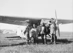 Tre flygare och en man i kostym står framför tyskt flygplan Bayriche Flugzeug Werke, BFW M.18d märkt D-1812, på ett flygfält, omkring 1930-1931. Tredje mannen från vänster är Arvid Flory.