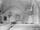 Interiör av Herrestad kyrka. Bilden visar hur kyrkan tog sig ut efter 1851 års grundliga renovering då bland annat altardisken tillkom. Från tiden kan sannolikt även räknas kaminen med sitt värmespridande rökrör. Predikstolen är emellertid av mycket äldre datum, inköpt redan år 1687 från Vadstena och bär mäster Måns Gabrielssons hand.