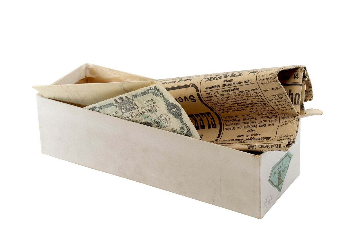 "En hälsning till upphittaren" - låda innehållande Gefle-posten, enkronasedel och ett brev från Fränkel & Bellander, 1914.