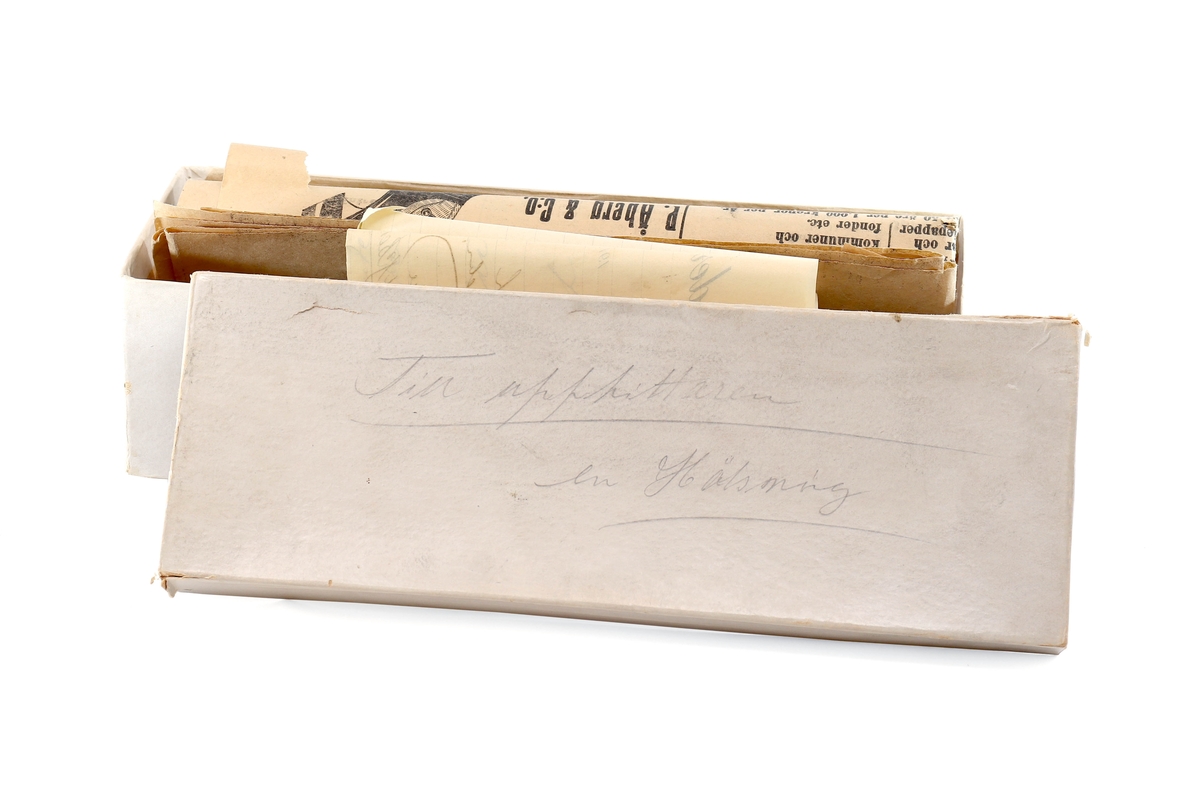 "En hälsning till upphittaren" - låda innehållande Gefle-posten, enkronasedel och ett brev från Fränkel & Bellander, 1914.