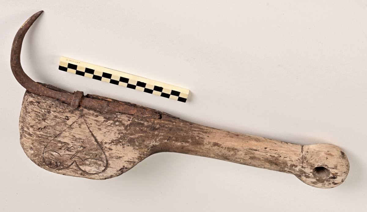 Kraftig høtt med skaft i tre, og med kraftig klo i stål, som er innfelt i skaftets underside. Skaftet har hull i motsatt ende av kloa. Hullet er beregnet for tau, slik at den kan henges opp.