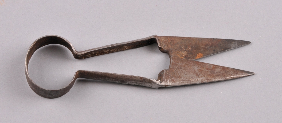 Lita saks av eit stykke metall. Forma som ein ring, der det stikk ut to litt skråstengar. I enden er desse stengane flata ut og spissa, slik at dei dannar blad på saksa. På denne måten blir saksa som ei fjær og kan brukast til å "trimme" barten.