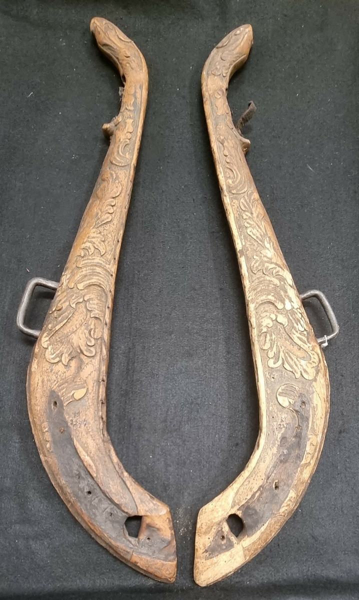 Ett par vackert snidade bogträn utan puta, omålade 2 ställ bjällror av metall, 2 lösa, från Blixtorp, Lilla Edet, Västergötland. Köpta av Bratt för 7 kr.