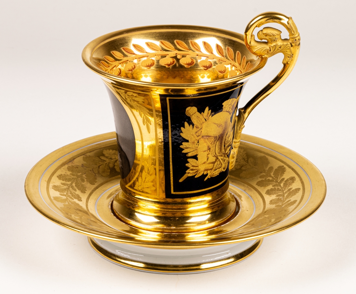 Karl XIII:S kopp.
Kopp med fat från Daite Freies i Paris, omkring 1800.
Koppens höjd 9.5 cm. Fatets diameter 16,5 cm.
Koppen bär på ena sidan Karl XIII:s bild och är på motstående sida dekorerad med ett par antika hjälmar.
Dekor i empirestil i guld och blått.
En grepe med örnhuvud och palmettdekor. Fatet är dekorerat med en eklövskrans.