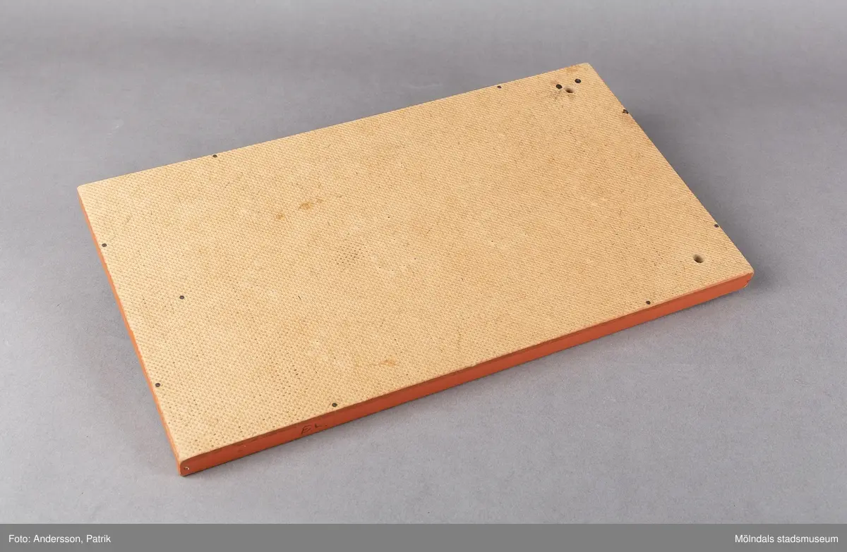 Fortunaspel bestående av en bottenplatta av bemålad masonit med kanter och ett fack av bemålat trä.
I facket finns en kort kö, två fotpinnar och metallkulor. Planen är försedd med spikar och en grön dekor som anger värdet. På vänster ytterkant är initialerna E.L skrivna med blyerts.
Spelet är handgjort och målat med orange färg. Punkter och siffror är målade i grön färg. Längst ned på spelet fins ett litet fack med speltillbehör. I facket finns en kort kö, två fotpinnar och metallkulor. Facket har ett lock som kan skjutas in. Spelet är förmodligen tillverkat på 50-talet och är en föregångare till flipperspelet. Poäng uppnås genom att kulor skjuts iväg med en pinne  och därefter hamnar i fack med olika värden.