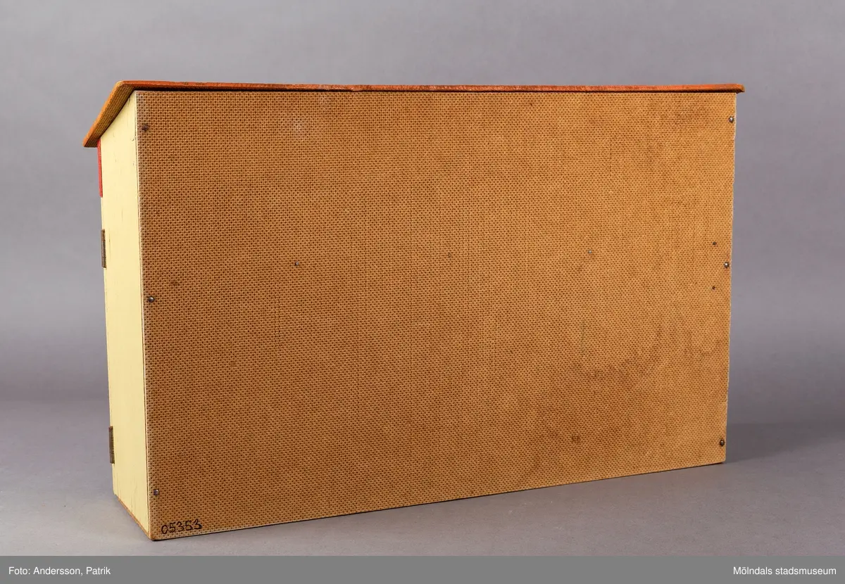 Leksak i trä i form av en liten affär. På framsidan finns texten "Kährs Diversehandel", dekor i form av två skyltfönster och en liten dörr med ett handtag i metall. Fronten består av två luckor går att öppna. Inuti finns en butiksinredning med gröna hyllor och en lös röd butiksdisk med sex gula utdragbara lådor.
Allt är tillverkat i trä. Affärens utsida är målad i en ljusgul färg, med ett tak som är bemålat med tegelröda tegelpannor. Under takåsen löper en röd list med texten "Kährs Diversehandel" målat med vita bokstäver.
Leksaksbutiken är tillverkad av Kährs. Företaget grundades 1857 och tillverkade till en början leksaker och möbler, men tillverkningen övergick efter andra världskriget alltmer till att omfatta endast dörrar och golv.