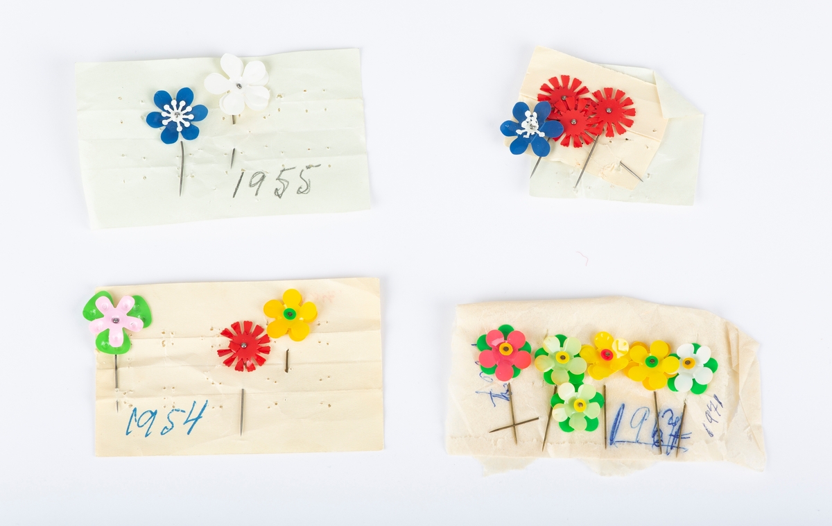 10 sløyfer av forskjellig format. Norske farger. Flere maiblomster i forskjellige farger. Disse ble solgt av Sanitetsforeningen. Alt ligger i pappeske