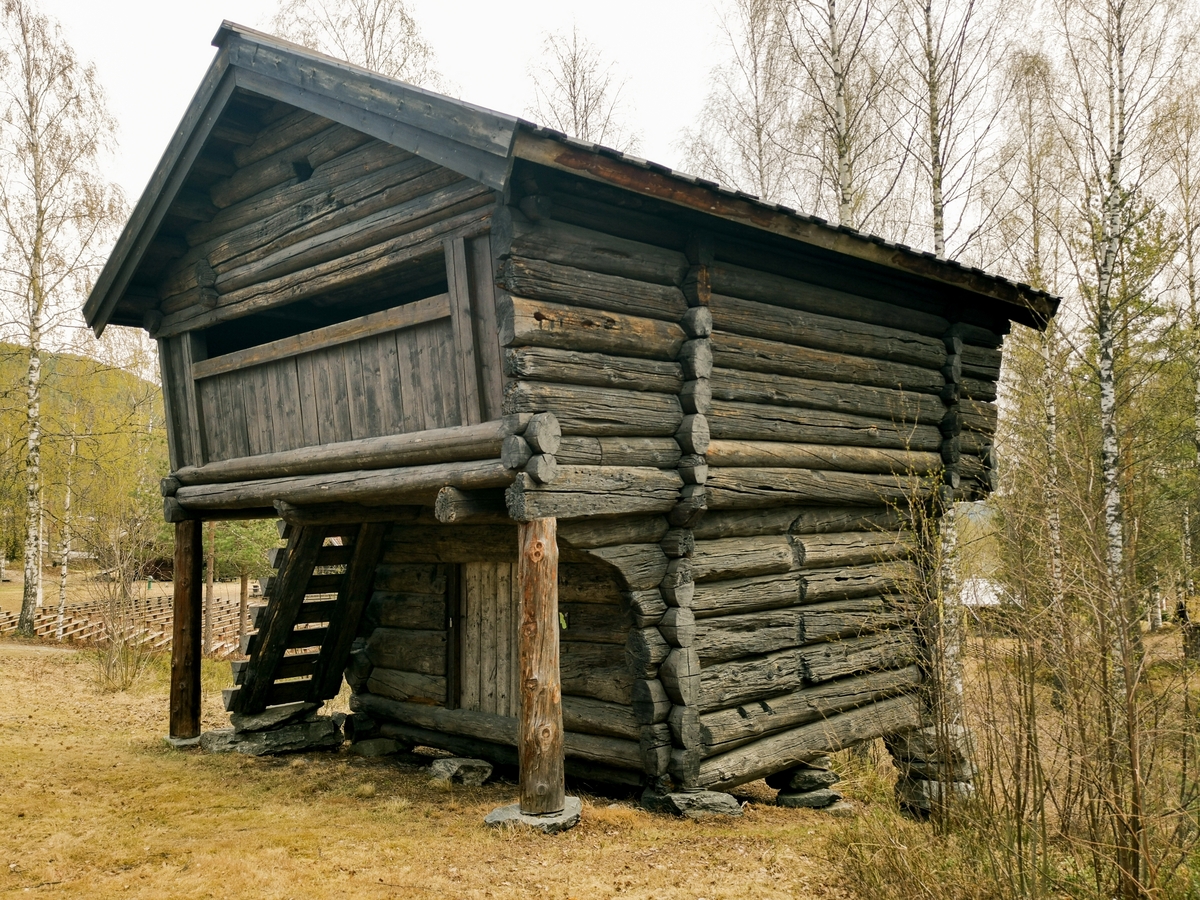 Tømret loft med åpen utkraget svalgang i andre etasje på to av kortsidene og den ene langsiden.