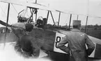 Tre militärer vid flygplan Albatros på ett flygfält. Omkring år 1920.