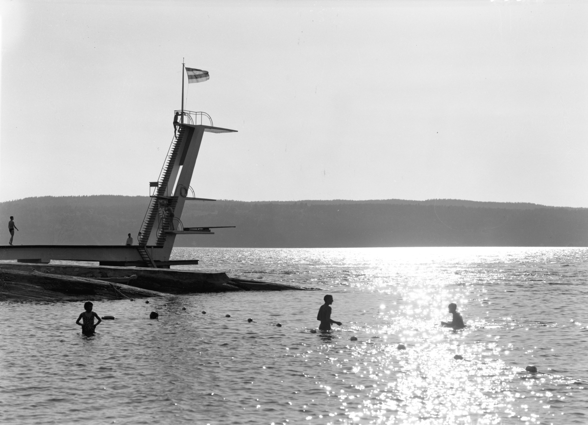 Svarthvittbilde av stupetårnet og badegjester på Ingierstrand bad. Anlegget sto ferdig i 1934.