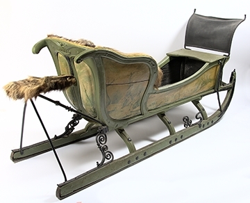 Släde, enspännare av furuträ. Grönmålad. Med järnbeslag. Kuskbockssadel ("hundsfott") samt plats för en passagerare. I sätet en infälld lucka, förvaringsutrymme. Kuskbocksbrädan samt sätets sid- och ryggstycken stoppade med hö, foder juteväv, klädda med grävlingskinn. Framtill stänkskydd för passageraren av svart impregnerad duk

Rikt dekorerad med målningar i Rokokostil.