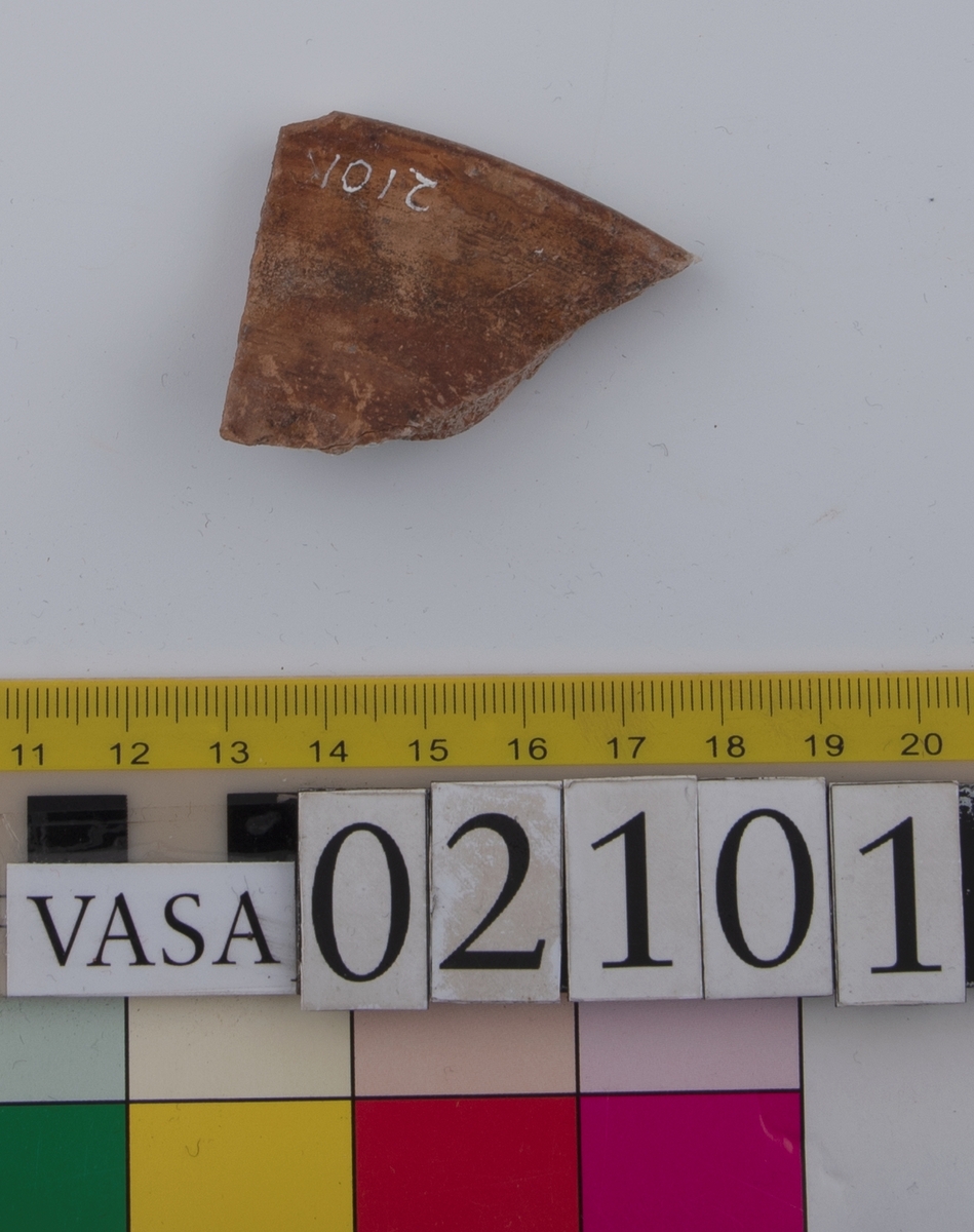 Två skärvor från ett grönglaserat keramikfat.
Fragment av mynningsrand (bräm) med bit av plan botten av fat. Profilerad bräm. Insida blyglaserad grön. Utsida oglaserad. Undersidan av den platta botten är räfflad.