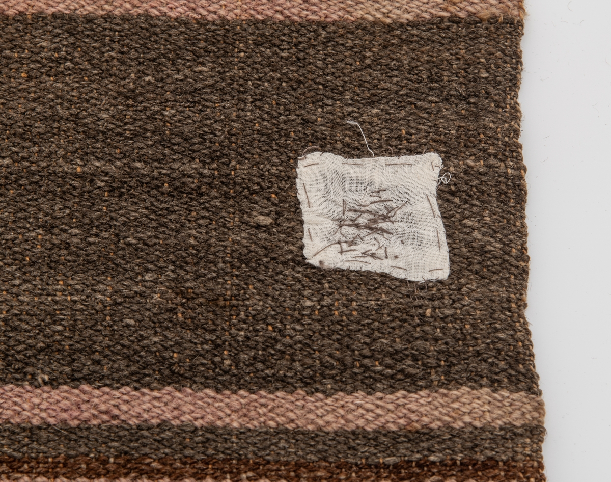 Initialer: OADP brodert litt nedenfor overkanten på teppet. 