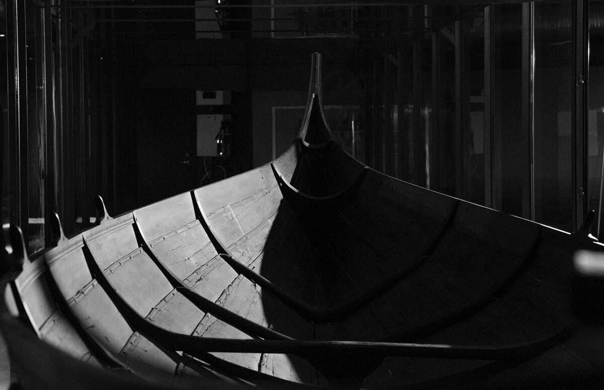Original vikingbåt fra Gokstadfunnet utstilt i monter i utstilling på Norsk Maritimt Museum.