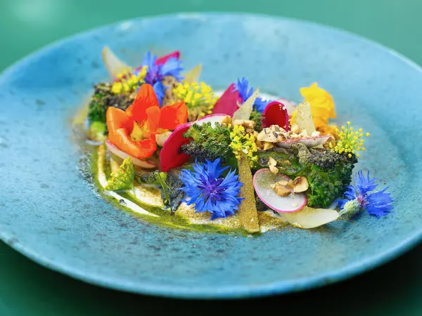 En blå tallerken med en fargerik grønnsaksrett.  