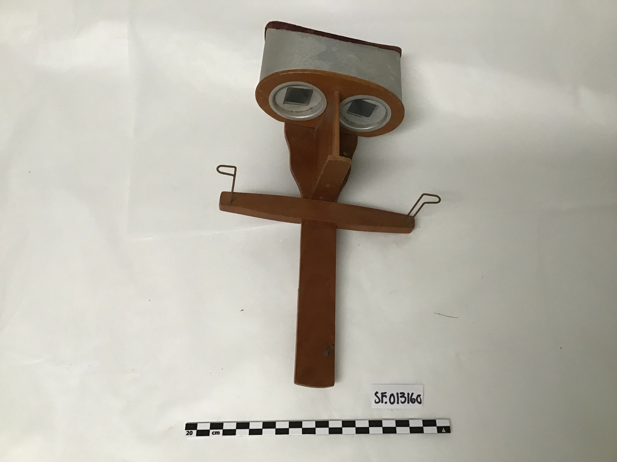 Apparat til stereofotografier. To linser , handtak og festeanordning for fotografier.
