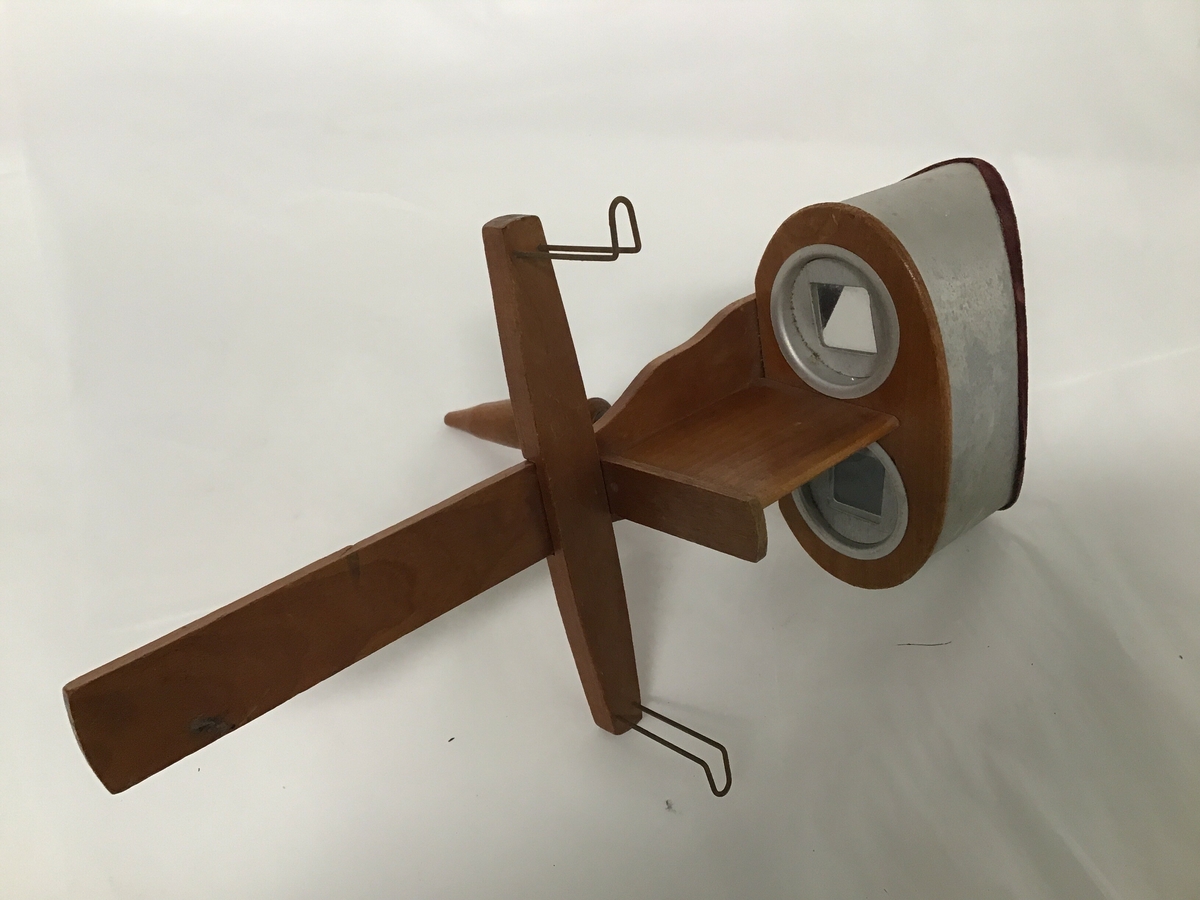 Apparat til stereofotografier. To linser , handtak og festeanordning for fotografier.
