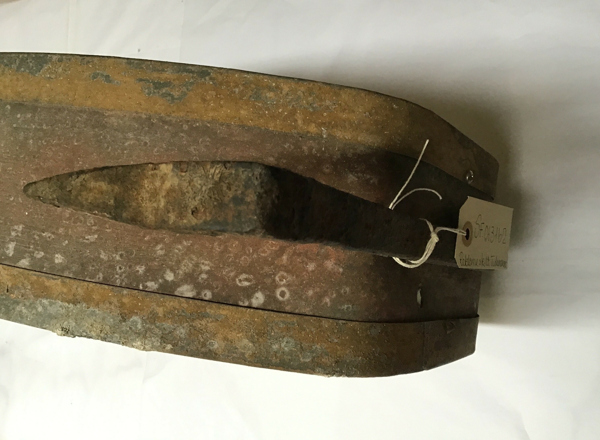 Reklameskilt for Tiedemanns tobakksvarer. Skiltet er avlang, ellipseforma men med skrå kortsider. Ulike motiv på sidene, det er opplegg for elektrisk lys med lyspærer  inne i skiltet.