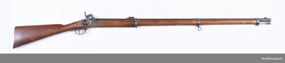 Gevär m/1850, typ Wrede med slaglås.
Piplängd med patentsvansskruven: 980 mm. Antal räfflor: 6. Räffelstigning: 1 varv på 112,8 cm. Loppets rel. längd: 80 kal. Kulans diameter, över styrgördlarna: 12 mm. Kulans längd: 26,73 mm. Kulvikt: 23,1 g. Krutladdningens vikt: 6,375 g. Utgångshastighet: 1 620 fot =481 m/sek.
Pipan är brungjord och helt och hållet rund. Ett med tunn fot försett mässingskorn är fastlött på översidan av en stadig, fyrkantig järnklack, som sitter 2,3 cm bakom mynningen och som även tjänstgör som bajonettklack. Siktet är ett vinkelklaffesikte, som sitter 20,5 cm framför svansskruvssstjärtens bakände och som är placerat på en 43 mm lång, vid pipan fastlödd klack. Det har siktpunkter för avstånd mellan 600 cch 2 000 fot. En i siktfoten anbringad fjäder håller siktet stilla antingen den korta eller långa sikteklaffen är vänd uppåy. Pipan har gråhärdad, 3 mm långg patensvansskruv, som är försedd med stjärt. På pipans undersidan mitt på gränsen mellan pipa och svansskruv sitter en med utstående, cylindriskt huvud försedd stoppskruv. På patentsvansskruvens högra sida är den med eldskärm försedda snäckan fastlödd. I snäckan är knallhattstappen ioskruvad. På svansskruvsstjärten står numret 558. På pipans översida är inslaget stort H (Huskvarna Vapenfabrik) HG och TLlN, på undersida P, 2,2, PJF och 1862.
Låset har platt, i jämnhöd med stockens yta nedfällt bleck samt är framåtvänt och ett kedjelås, dvs. änden på slagfjäderns långa nedre arm är med en kedjelänk försenad med ett från nötens framdel utgående ursprång. Slagfjädern fasthålles ej av någon skruv, utan dess korta arm har en cylindrikt tapp, som sitter i ett hål på låsblecket och stöder dessutom mot en särskild, från det sistnämda utgående klack. Hanen är kraftig och kullig. Tumgreppet är rakt och uppttll på framsidan krusat. Nedtill i slagarmen finns en 7 mm djup, framtill med genom  bred sotinga försedd urtagning, vars botten är slagytan. På låsbleckets utsida står stort  H, 1862 och 558, på insidan IL. Låset har ej hakspänn, vilket ersättes av det låga halvspännet. Låset fasthålles av två skruvar, av vilket dock blott den bakre går genom stockrn och inskruvas i en cylindrisk förstärkning  på låsblecket ovanför nöten. Den främre är en träskruv, vilken är insatt vid låsutskärningens främre ände. Denna skruv har ej skåra, utan i stället har huvrdet ett par vylondeiaka hål, i vilka ett passande instrument insattes då man ville taga ut skruven. Detta är dock i vanliga fall ej nödvändigt. När man tager bort låset skruvar man ut den bakre låsskruven. Låsbleckets framände har en halvcirkelformig urtagning, som bakifrån inskjutes under den främre låsskruvens i låsutskärningen fristående huvud.
Stocken är av björk och brunbetsad. Framstocken har en avsats för vart och ett av de tre banden. På stockens högra sida bakom sidblecket står numret 558, årtalet 1862 samt ett par otydliga bokstäver. Laddstocksfjädern är anbringad i piprännans botten och fasthålles av ett stift. Den går genom en urtagning ned i laddstocksrännan.
Bakplåten, avtryckareblecket, sidblecket och varbygeln är av mässing, banden av gråhärdat järn. Bakplåten fasthålles av två skruvar och har en mycket kort, framtill avrundad spets, som går in över kolvryggen. Sidblecket är cirkelrunt med en diam. av 18 mm samt är försett med en kort, bakåtriktad, flik. Det är nedfält i jämhöjd med stockens yta. Varbygelns rätt korta bakre arm fasthålles av en träskruv, den främre av den nedifrån isatta korsskruven. Alla banden är jämnbreda och svagt kulliga. Tre ändar är på undersidan nedåtvikta och förenas genom en skruv, som nitad i änden för att den ej skall kunna vridas ur bandet. Bandfjädrar finns ej, utan i stället kan varje band dragas åt mer eller mindre hårt genom bandskruven.