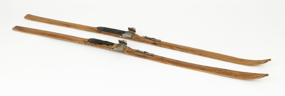 PATENT NO 1, det står også speisfisert hva som er høyre og venstre ski med L - R. Ligner på en KANDAHAR BINDING, mangler wiren til hælfeste. Skiene har en svak kromning foran og bak fotsteget. Tuppen har en svak bøy, tuppene har også det vi kaller "sukkerbittupp" Skiene er også litt oppbygd bak. 

