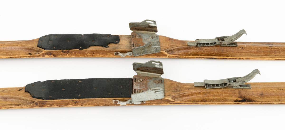 PATENT NO 1, det står også speisfisert hva som er høyre og venstre ski med L - R. Ligner på en KANDAHAR BINDING, mangler wiren til hælfeste. Skiene har en svak kromning foran og bak fotsteget. Tuppen har en svak bøy, tuppene har også det vi kaller "sukkerbittupp" Skiene er også litt oppbygd bak. 
