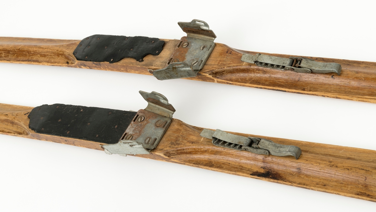 PATENT NO 1, det står også speisfisert hva som er høyre og venstre ski med L - R. Ligner på en KANDAHAR BINDING, mangler wiren til hælfeste. Skiene har en svak kromning foran og bak fotsteget. Tuppen har en svak bøy, tuppene har også det vi kaller "sukkerbittupp" Skiene er også litt oppbygd bak. 
