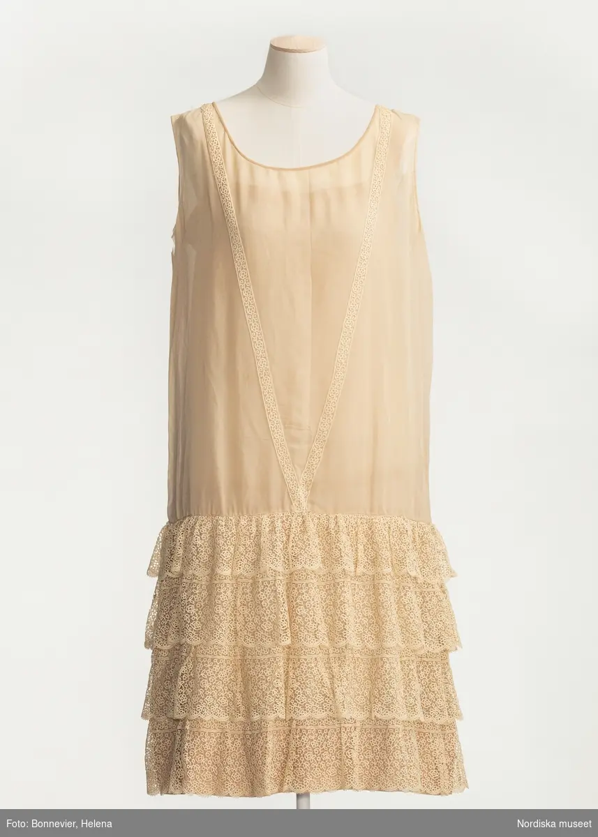 Ordered by Kerstin Stafsing née Jonsson (1899–1986). Delivered ca. 1925. Chiffon evening dress with lace flounces and a mother 
of pearl belt buckle in the shape of an owl’s head. Possibly after an original by Coco Chanel.