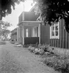 Bostadshus i byraden i Kullarp, Ydre härad, Östergötland. Plantering framför byggnaden.