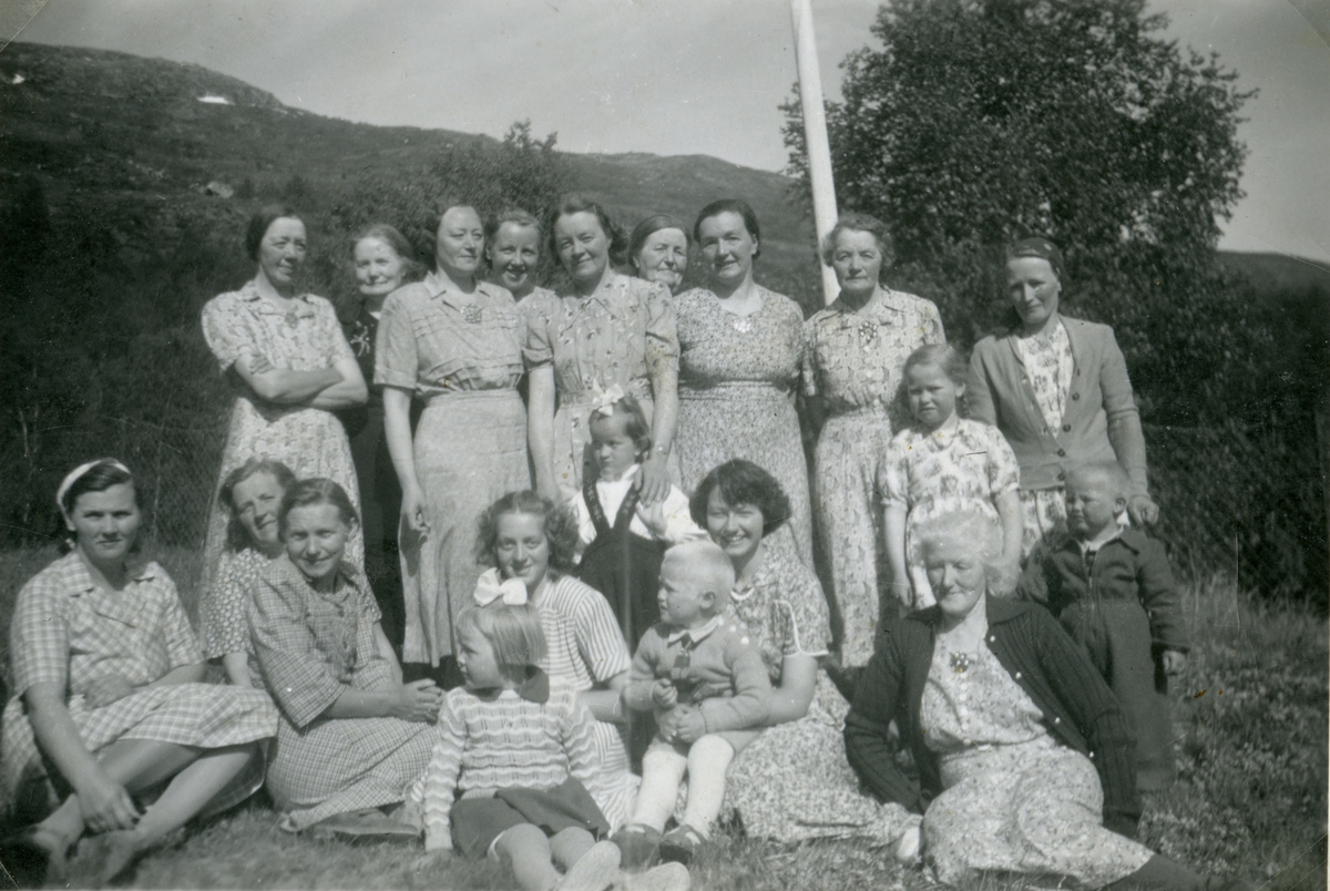 Framme frå venstre: Dagny Leine, Bertha Hamre, Ingeborg Oldre, Kirsti Leine med Margrete Leine framfor seg, Martha Nordland med Nils Leine på fanget og Gjertrud Nordland. Bak frå venstre: Berit Leine, Ingeborg Nordland, Anna Leine, Margrete Leine, Olga Sparstad med ei ukjent jente framfor seg, Sofie Hafsnor(Oldre), Karen Nordland, Marit Sparstad, Anna Hamre med ungane Sigrid og Andris Hamre framfor seg