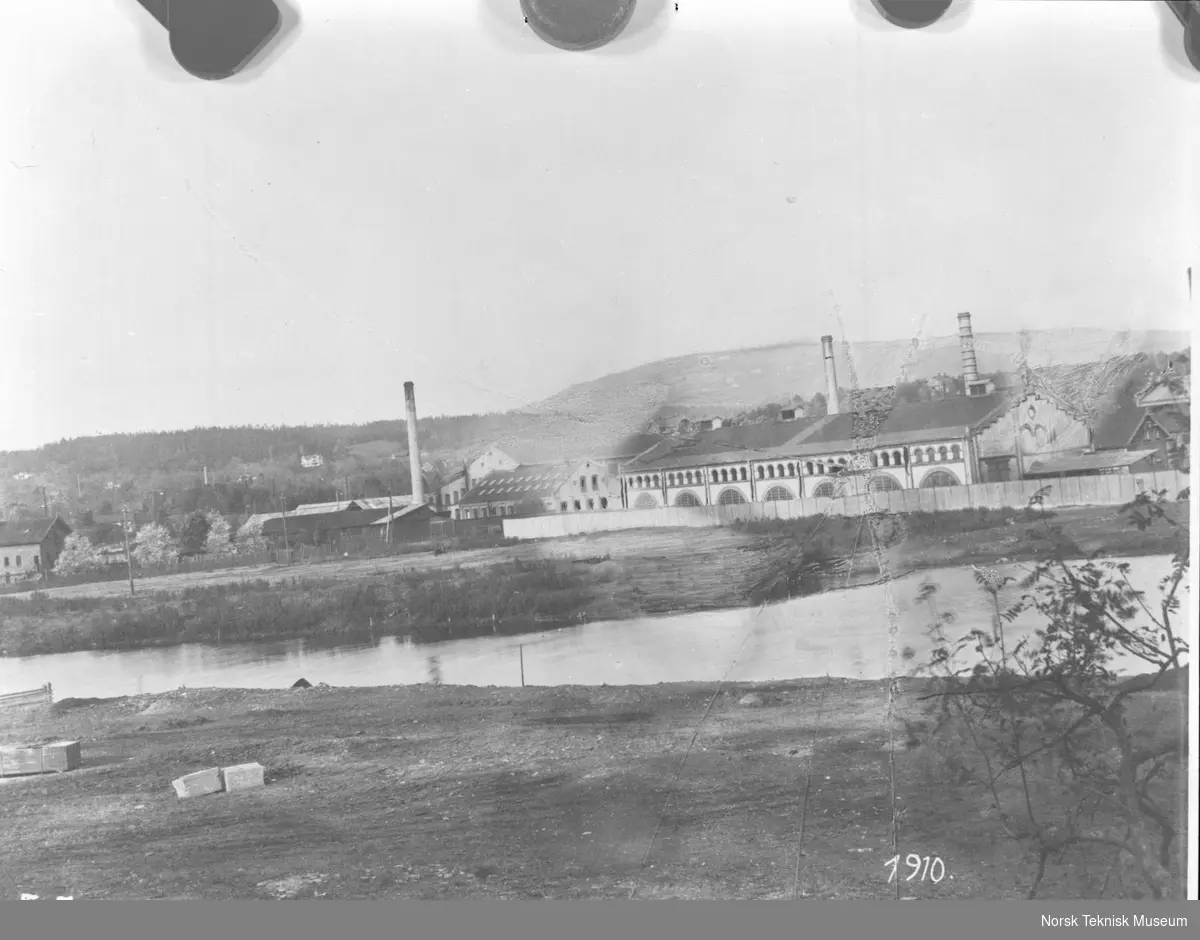 Støperiet tilhørende NEBB's fabrikkanlegg på Skøyen, vann i forgrunnen og åser i bakgrunnen : bygget i 1900