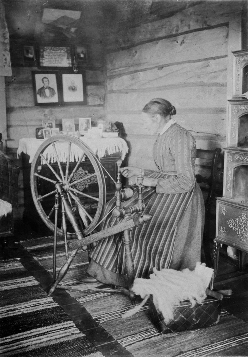 Spinning. Ei eldre kvinne sitter og spinner på rokk