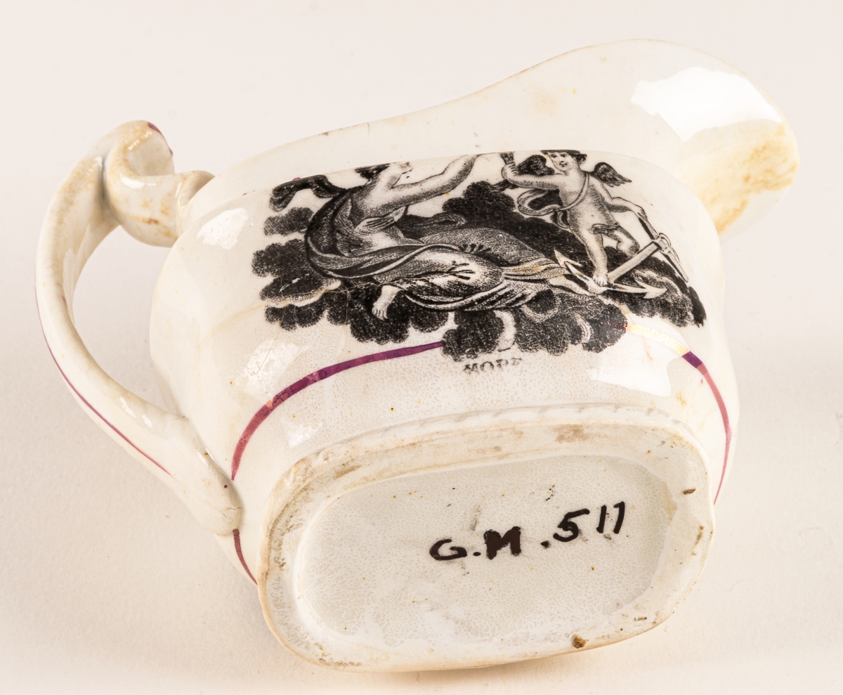 Gräddkanna av engelskt flintgods med rosa lyster. Dekor: allegoriska figurer i svart, samt röda växtband. Text "Faith & Hope".