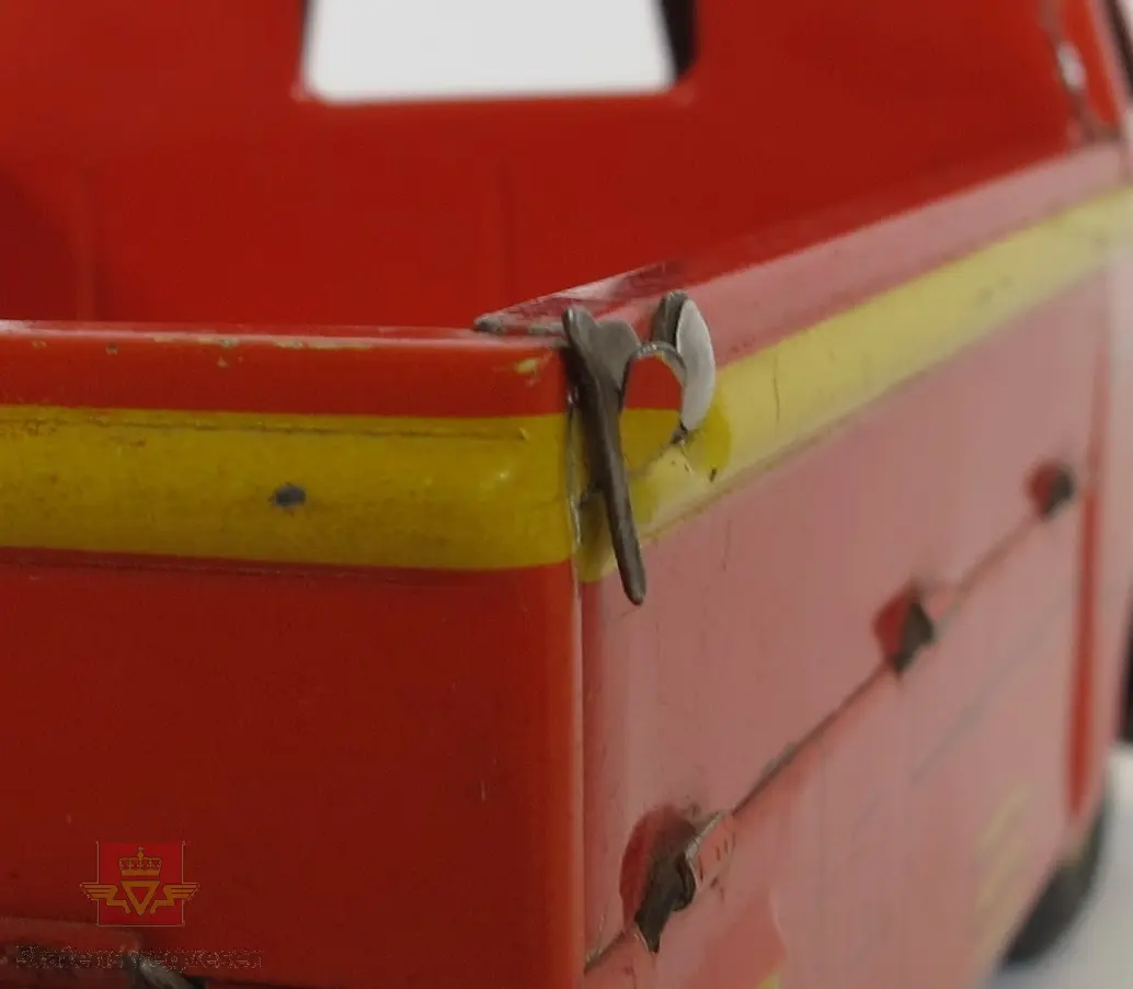 Opptrekkbar lekebil (pick-up) med 3 hjul hvor det siste mangler. Lagd hovedsakelig av tinn. Lasteplanet til bilen har lemmer som kan slåes ned og festes med hengsler. Opptrekk-nøkkelen mangler.