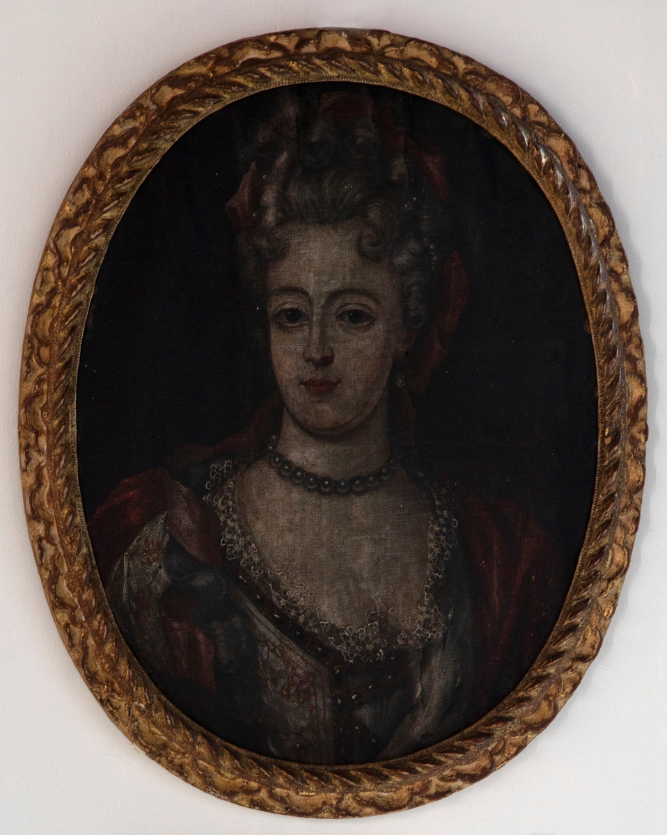 Brystbilde av en kvinne med grå perlekjede og rødt silkebånd i håret. Kvinnen er iført en lys kjole med hvit kniplingskant og har et rødt sjal over venstre skuldre.