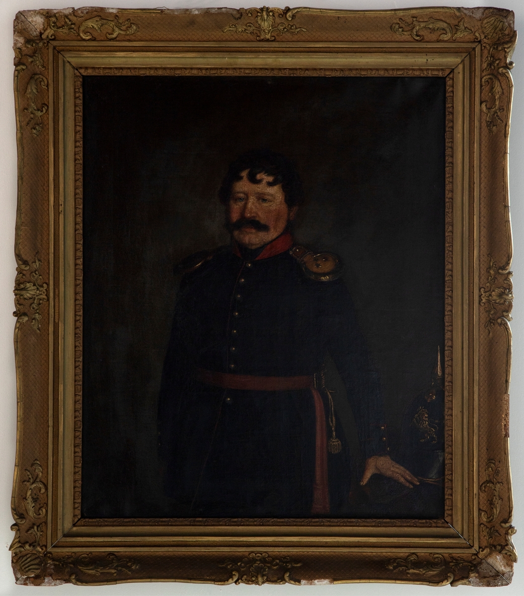 Portrett av en armékaptein i 3/4 figur. Mannen har mørke lokker som faller ned i pannen og en stor bart. Han er iført mørk uniform med distinksjoner på epålettene; tre stjerner på gull. Han bærer et bandolær med (antagelig) en sabel på venstre side. Den venstre hånden hviler mot et bord der hans hjelm står.