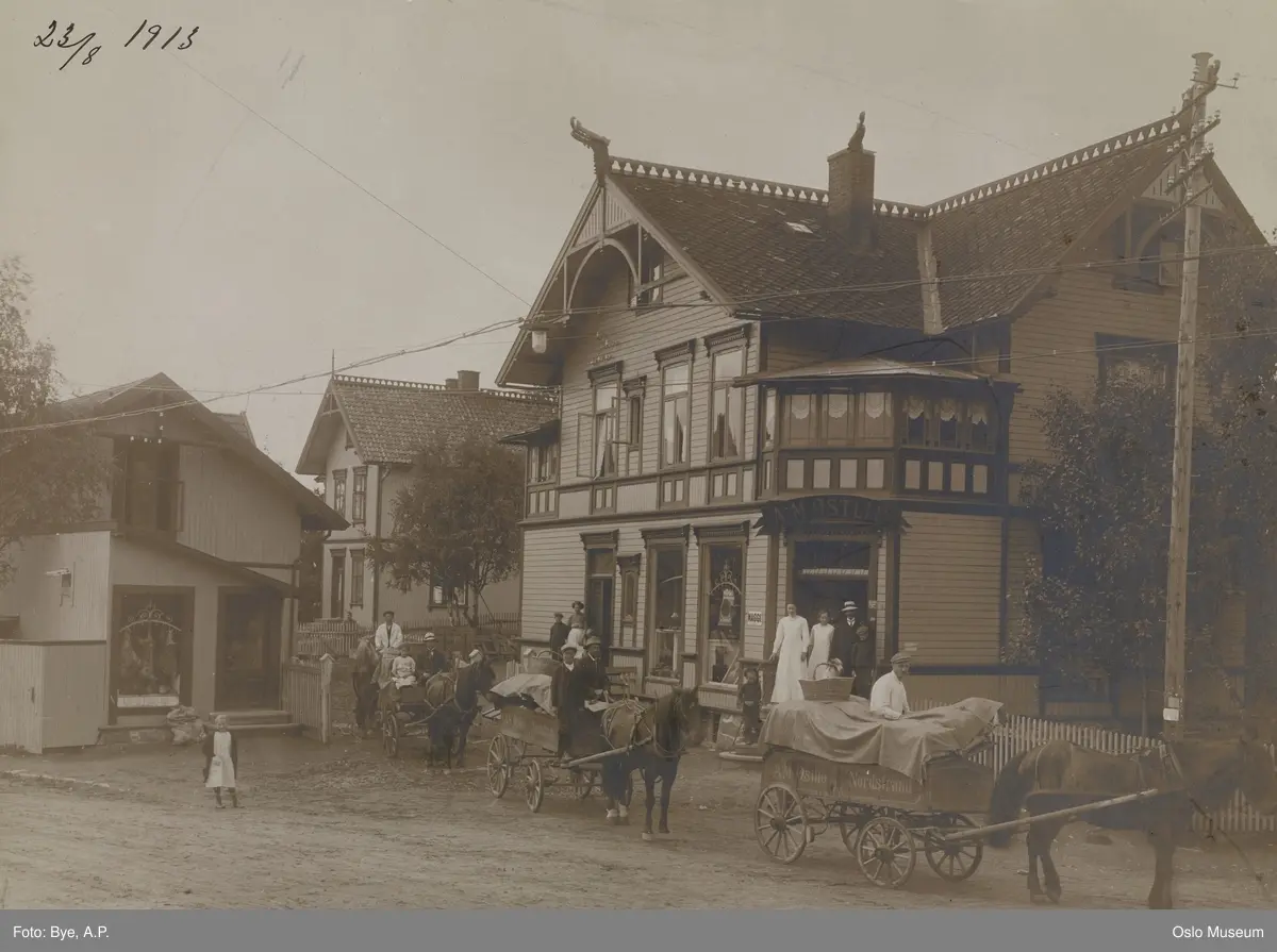 A.M. Østlie landhandel, gårdsplass, mennesker, hester, vogner