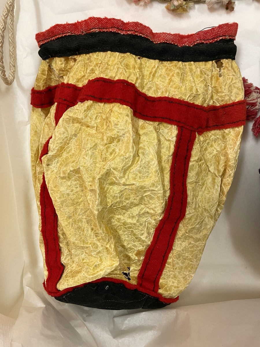 Av en oxblåsa garnerad med röda och svarta band, med dragsko.