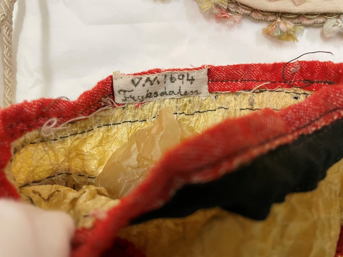 Av en oxblåsa garnerad med röda och svarta band, med dragsko.