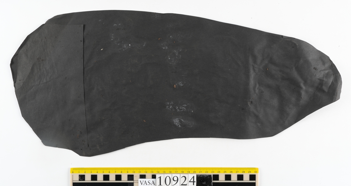 Delar och fragment av stövel.
Ett fragmentariskt stövelskaft. Skaftet är monterat på svart kartong av konserveringsenheten. På skaftets nedre del löper stygnshål. Lädret är mycket fragmentariskt och sprött.
Ett 100-tal större och mindre fragment. På några av fragmenten syns hål efter träpligg och stygn.
Lädret är sprött, tunt och fragmentariskt samt har rostliknande utfällningar.