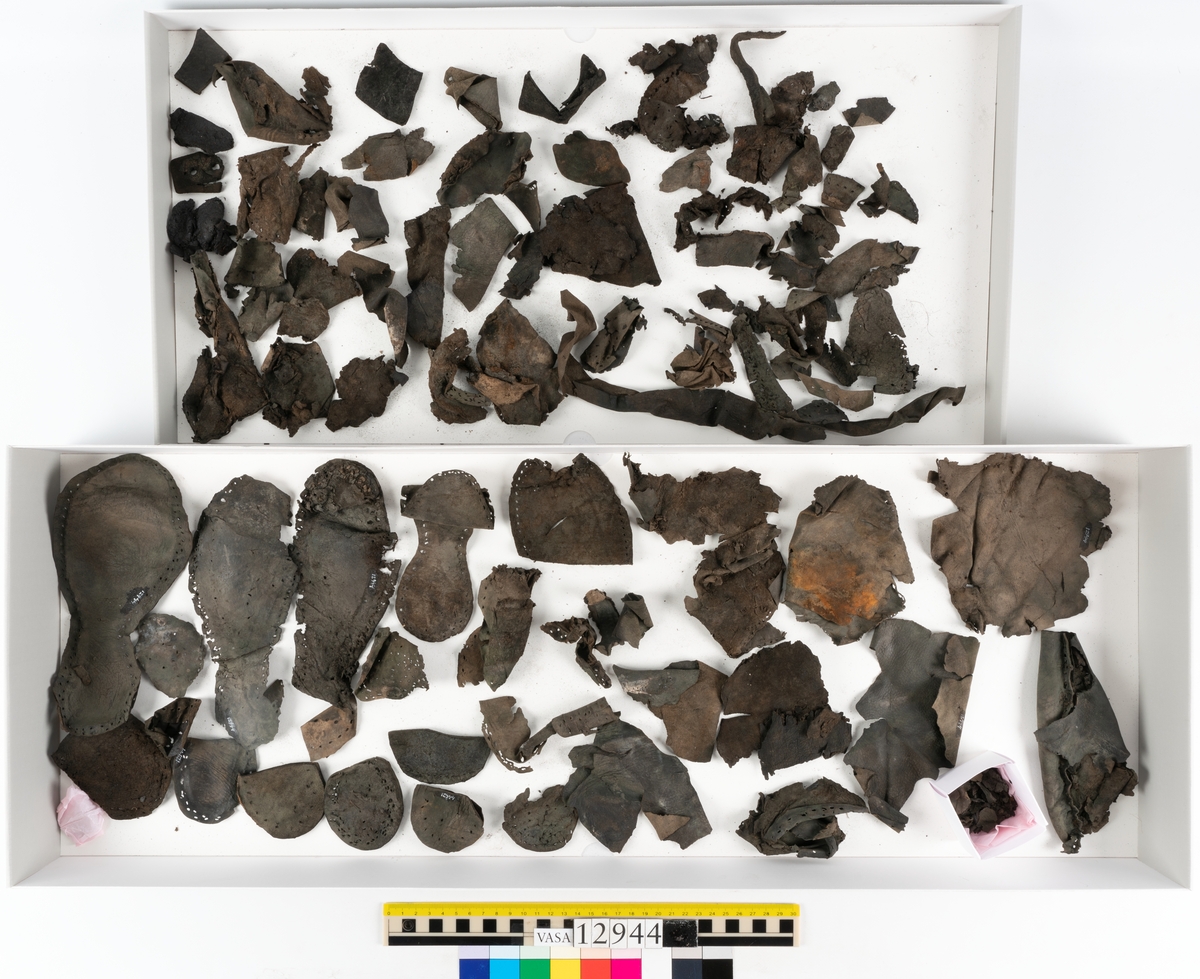 Ett 110-tal delar och fragment till sko: sulor, delar från klack, inlägg, ovanläder, slejf, ett näverfragment mm. Merparten av lädret är spaltat och fragmentariskt.