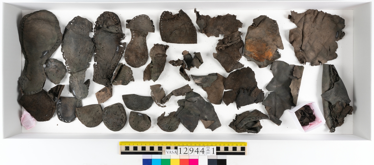Ett 110-tal delar och fragment till sko: sulor, delar från klack, inlägg, ovanläder, slejf, ett näverfragment mm. Merparten av lädret är spaltat och fragmentariskt.