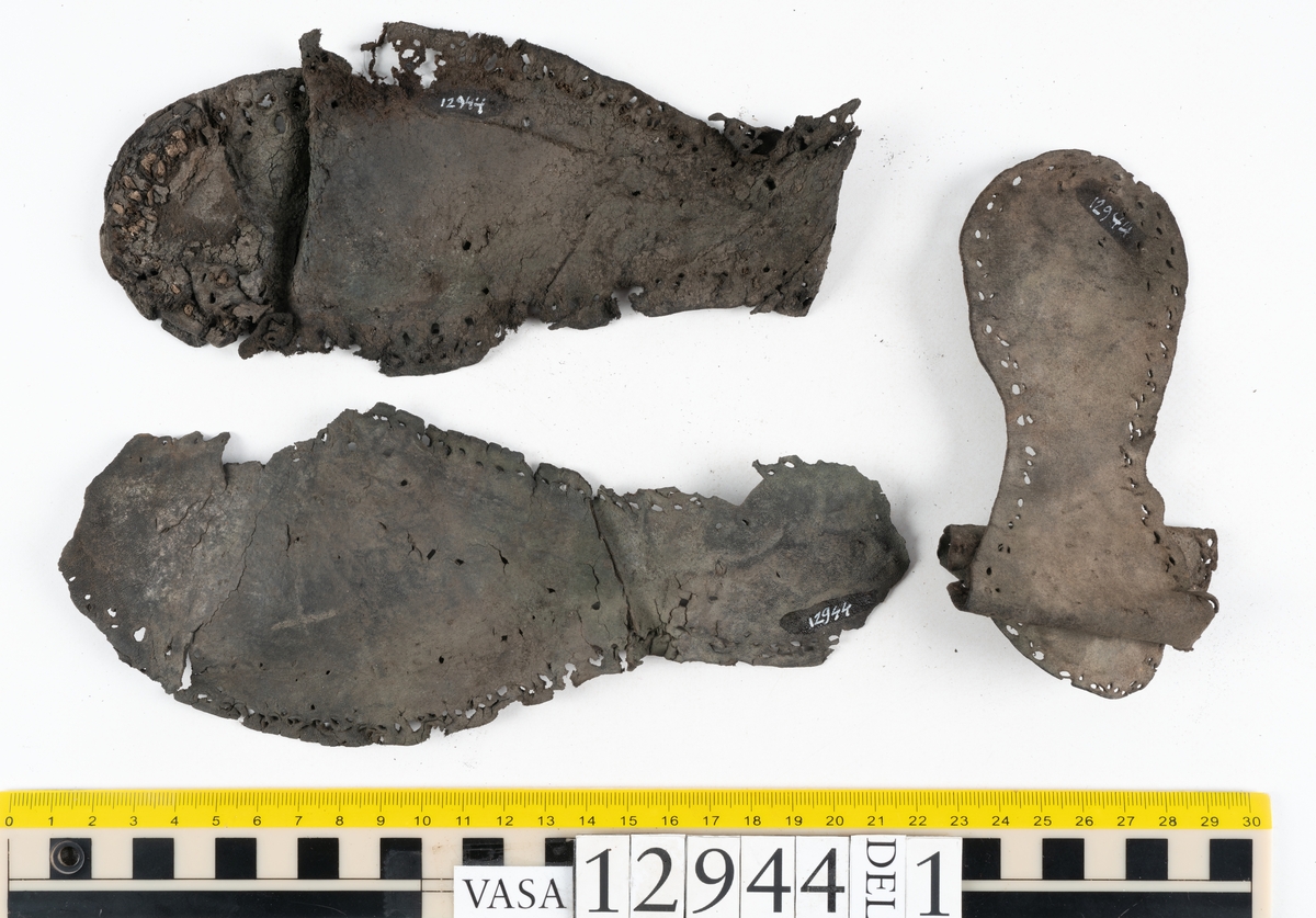 Ett 110-tal delar och fragment till sko: sulor, delar från klack, inlägg, ovanläder, slejf, ett näverfragment mm. Merparten av lädret är spaltat och fragmentariskt.