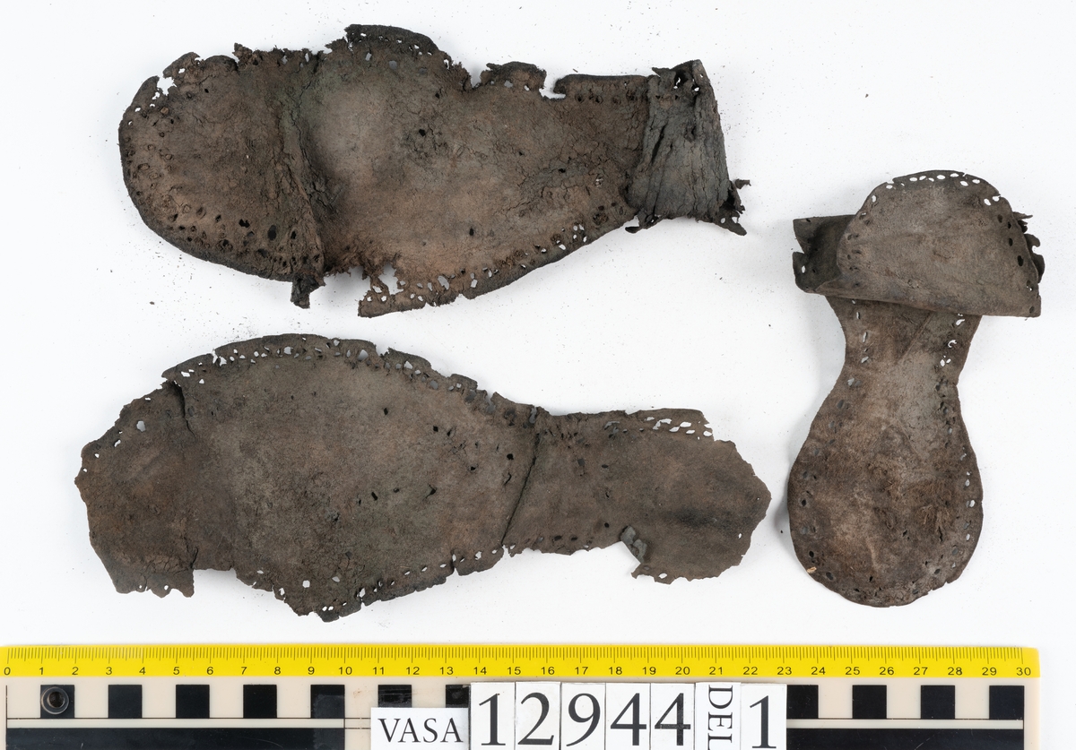 Ett 110-tal delar och fragment till sko: sulor, delar från klack, inlägg, ovanläder, slejf, ett näverfragment mm. Merparten av lädret är spaltat och fragmentariskt.