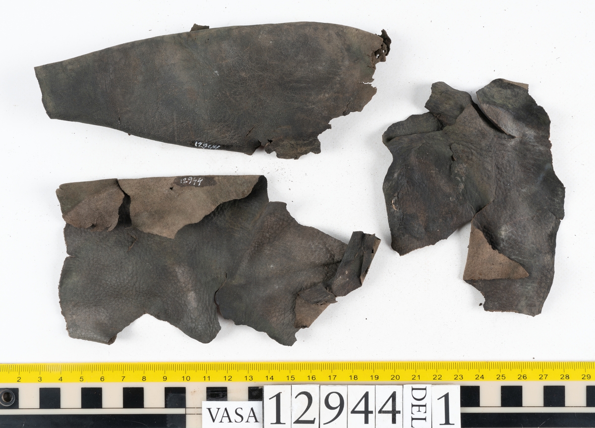 Ett 110-tal delar och fragment till sko: sulor, delar från klack, inlägg, ovanläder, slejf, ett näverfragment mm. Merparten av lädret är spaltat och fragmentariskt.